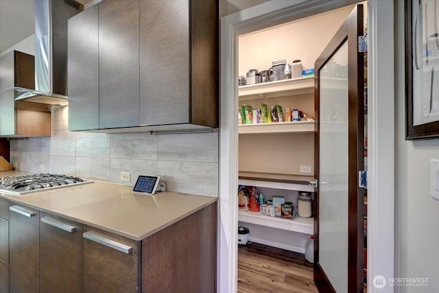 13406 SE 262nd St, Kent, WA 98042 - kitchen featuring stainless steel gas cooktop, wood finished floors, wall chimney range hood, decorative backsplash, and light countertops
