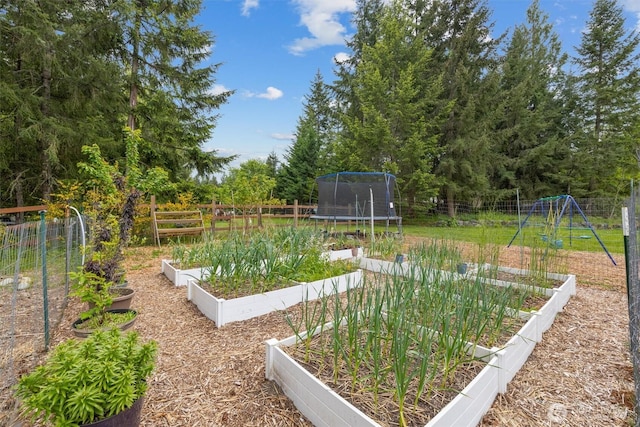 view of yard featuring a vegetable garden, a trampoline, and fence