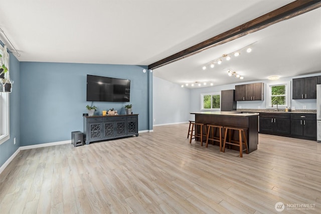 kitchen featuring a breakfast bar, a center island, light wood-type flooring, and plenty of natural light
