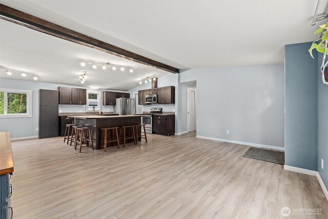 22011 167th St E, Orting, WA 98360 - kitchen featuring stainless steel appliances, a breakfast bar, dark brown cabinetry, and open floor plan