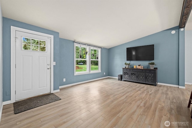 foyer featuring wood finished floors, baseboards, and lofted ceiling