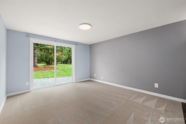 carpeted empty room featuring baseboards