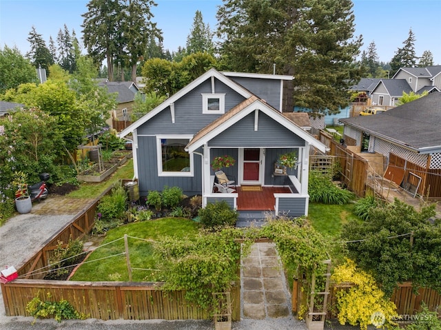 bungalow-style house with a fenced backyard, a vegetable garden, and board and batten siding