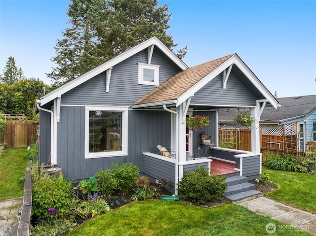 bungalow-style house with a shingled roof, a wooden deck, and board and batten siding