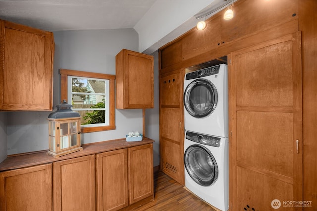 laundry room featuring stacked washer / drying machine and wood finished floors