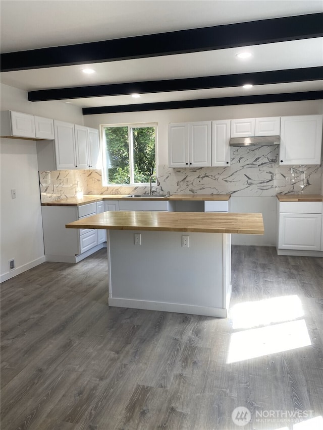 kitchen featuring a sink, white cabinets, butcher block countertops, tasteful backsplash, and beam ceiling
