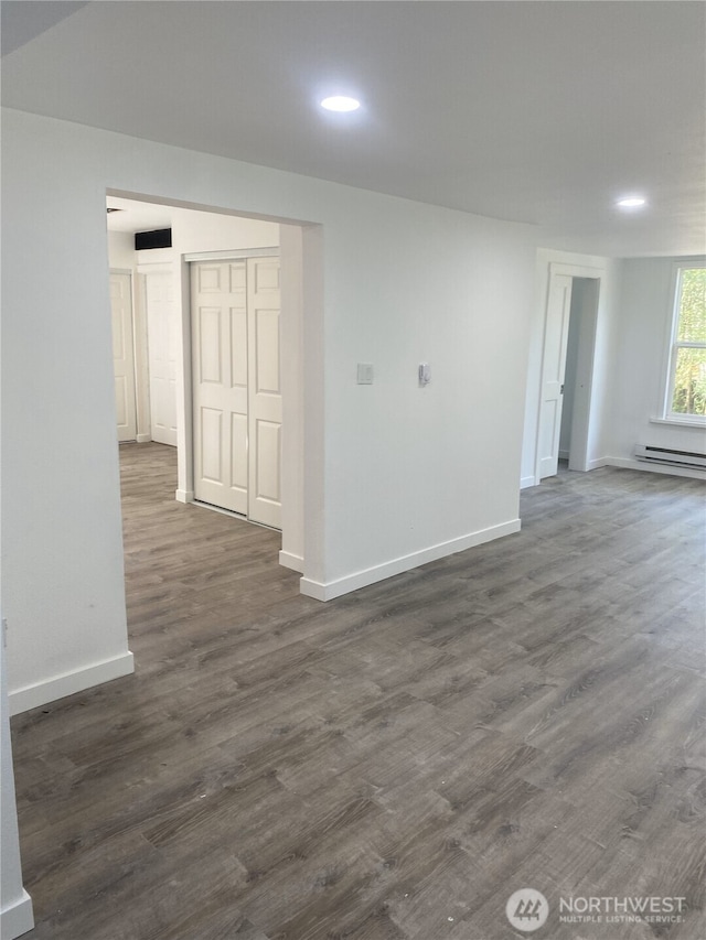 unfurnished room featuring baseboards, dark wood-type flooring, recessed lighting, and baseboard heating