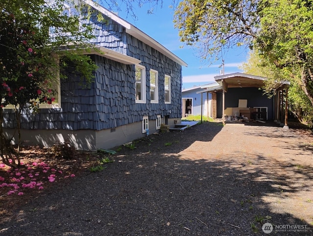 view of side of property featuring dirt driveway