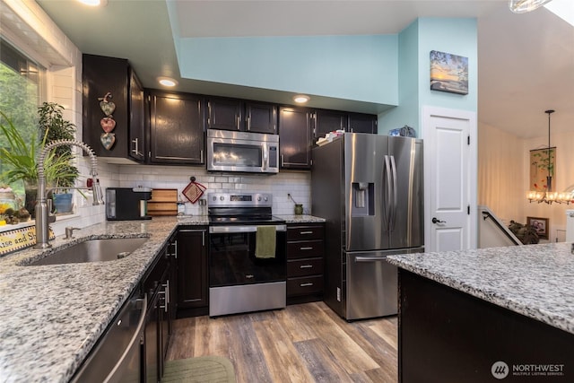 12128 167th Dr NE, Arlington, WA 98223 - kitchen with appliances with stainless steel finishes, a sink, backsplash, light stone countertops, and light wood finished floors