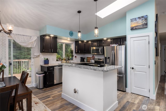 12128 167th Dr NE, Arlington, WA 98223 - kitchen with stainless steel appliances, a skylight, backsplash, dark wood-style flooring, and lofted ceiling