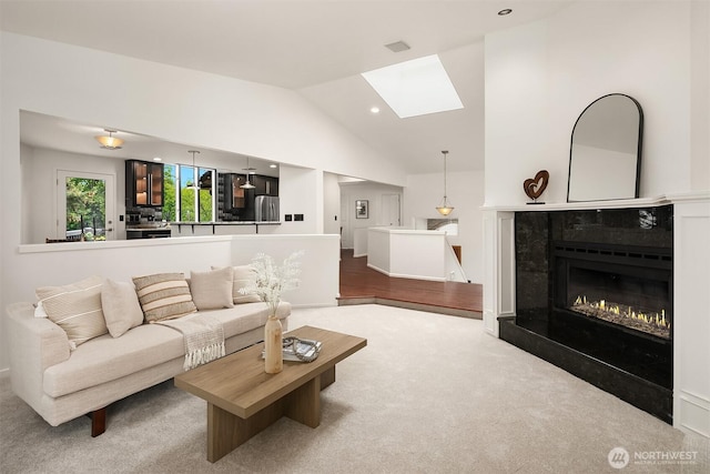 16910 73rd Pl W, Edmonds, WA 98026 - living room featuring a skylight, lofted ceiling, carpet, a premium fireplace, and recessed lighting