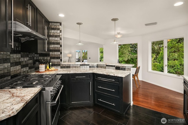 16910 73rd Pl W, Edmonds, WA 98026 - kitchen with stainless steel range, a peninsula, tasteful backsplash, light stone countertops, and dark cabinets