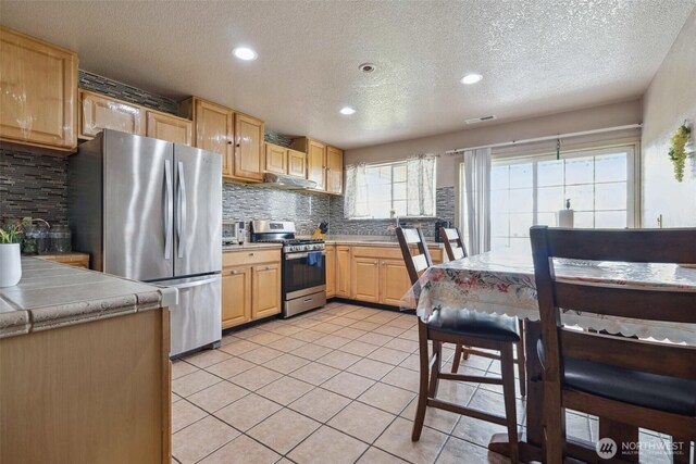 237 Reeds Rd, Touchet, WA 99360 - kitchen featuring appliances with stainless steel finishes, a textured ceiling, backsplash, light brown cabinetry, and recessed lighting
