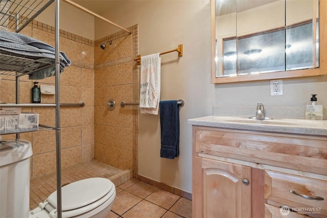 237 Reeds Rd, Touchet, WA 99360 - bathroom with toilet, tiled shower, vanity, tile patterned flooring, and baseboards
