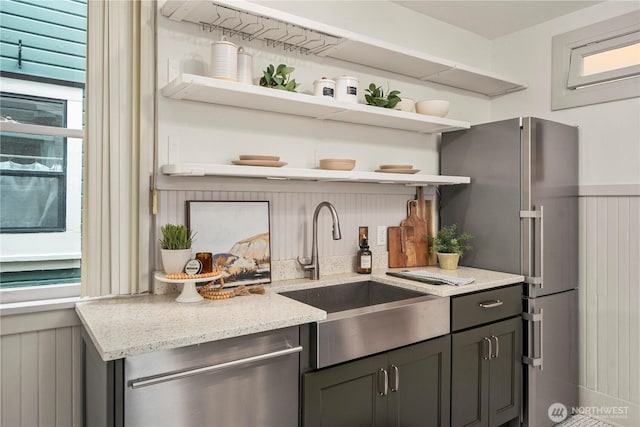 803 N 2nd St, Tacoma, WA 98403 - kitchen featuring open shelves, stainless steel appliances, a sink, light stone counters, and wainscoting