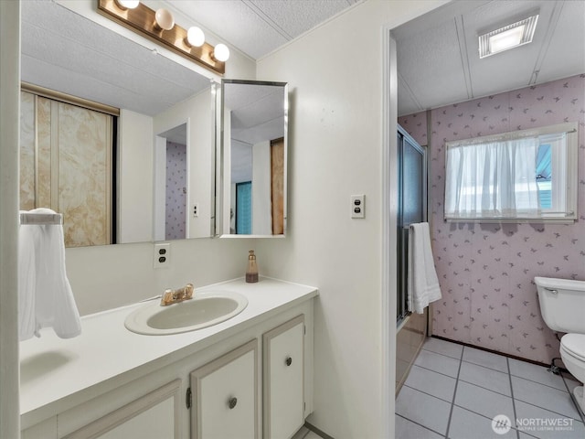 1415 84th St SE Unit 159, Everett, WA 98208 - full bath featuring tile patterned flooring, toilet, an enclosed shower, vanity, and wallpapered walls