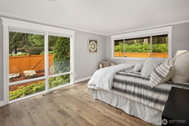13050 SE 21st Pl, Bellevue, WA 98005 - bedroom featuring crown molding, wood finished floors, multiple windows, and baseboards