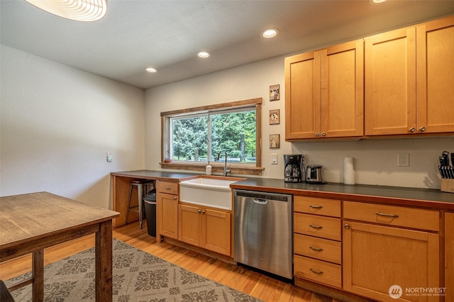 kitchen with stainless steel dishwasher, a sink, dark countertops, light wood-style flooring, and recessed lighting