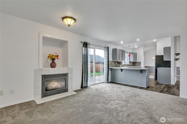 1108 200th Street Ct E, Spanaway, WA 98387 - unfurnished living room featuring dark colored carpet, baseboards, a fireplace, and recessed lighting