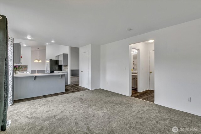 1108 200th Street Ct E, Spanaway, WA 98387 - unfurnished living room featuring dark colored carpet, baseboards, dark wood-style floors, and recessed lighting