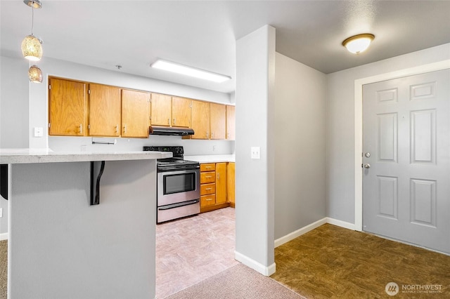 2900 W Marina Dr Unit 303, Moses Lake, WA 98837 - kitchen featuring stainless steel range with electric stovetop, under cabinet range hood, light countertops, pendant lighting, and a breakfast bar area