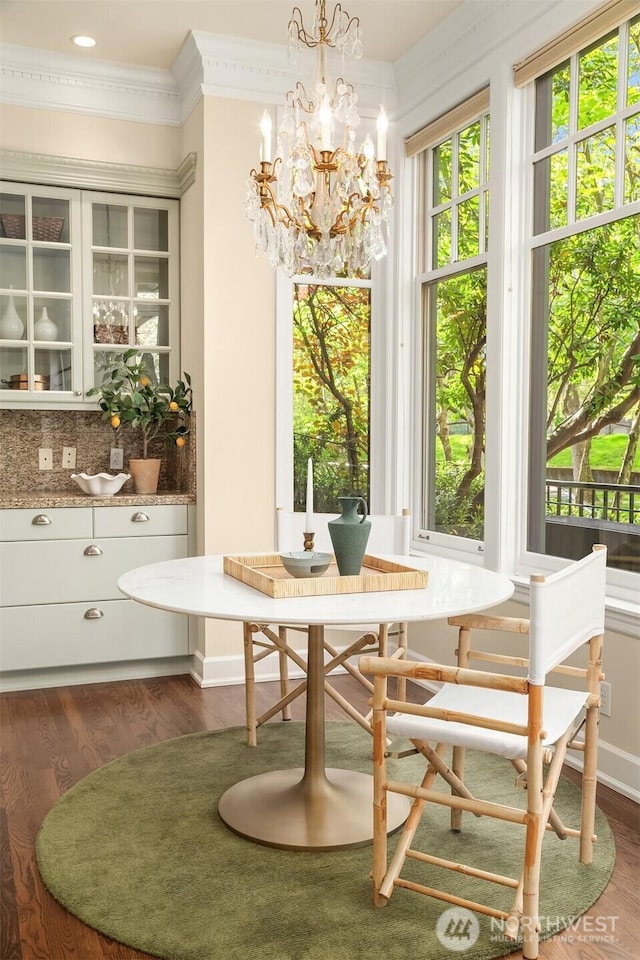 dining area featuring dark wood finished floors, healthy amount of natural light, and crown molding
