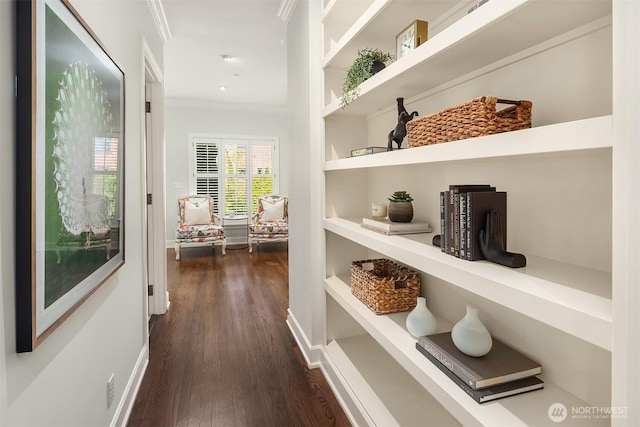 hallway with ornamental molding, dark wood-style flooring, and baseboards