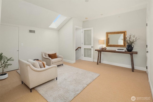 sitting room featuring a skylight, carpet floors, lofted ceiling, and baseboards