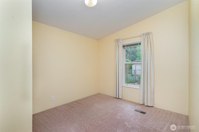 carpeted empty room with lofted ceiling