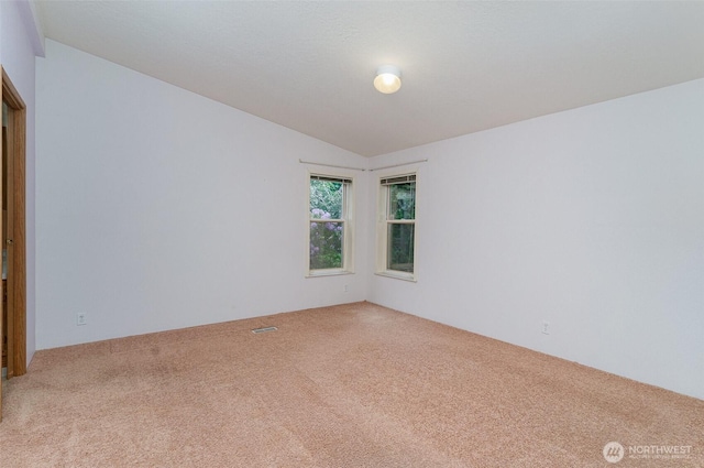 unfurnished room with carpet floors and vaulted ceiling