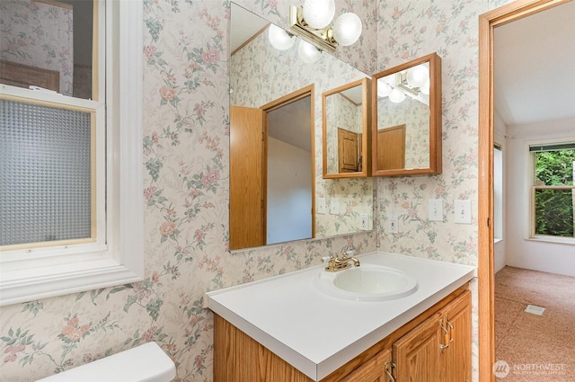 bathroom featuring vanity, toilet, and a chandelier