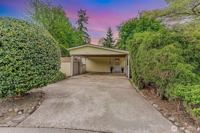 garage featuring driveway and a shed