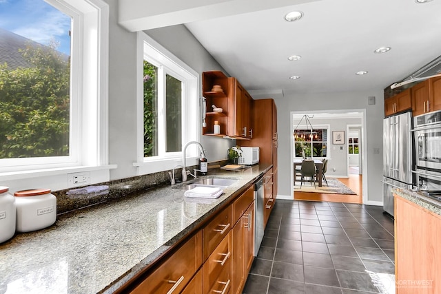 kitchen featuring a sink, appliances with stainless steel finishes, dark tile patterned flooring, plenty of natural light, and recessed lighting