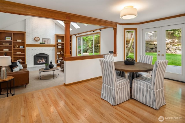4816 118th Ave NE, Kirkland, WA 98033 - dining area featuring french doors, vaulted ceiling, light wood-style flooring, a brick fireplace, and baseboards