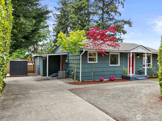 view of front of property featuring central AC unit, a storage shed, an outdoor structure, and driveway