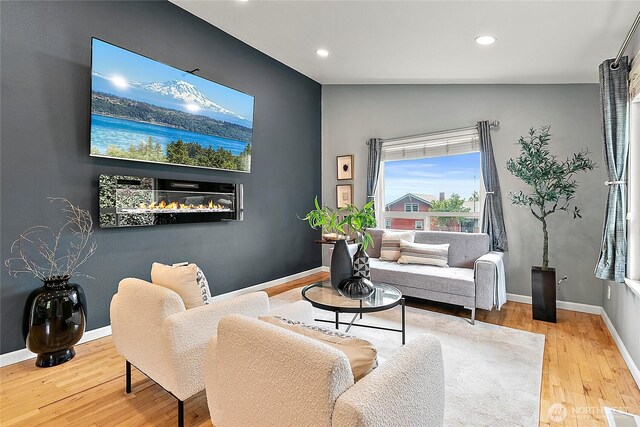 living area with wood finished floors, recessed lighting, and baseboards