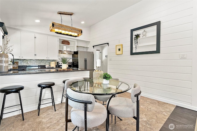 dining area with wooden walls and recessed lighting