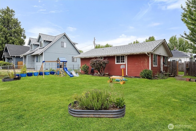 714 S 43rd St, Tacoma, WA 98418 - rear view of house featuring a playground, a fenced backyard, and a shingled roof