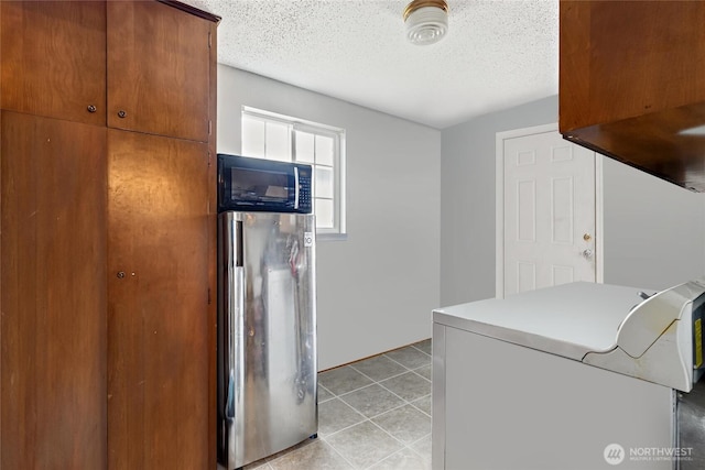 714 S 43rd St, Tacoma, WA 98418 - laundry room featuring a textured ceiling, light tile patterned flooring, and washer / dryer