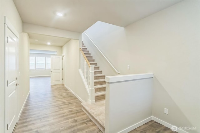 stairs with wood finished floors, baseboards, and recessed lighting