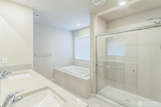 bathroom featuring a stall shower, a bath, backsplash, double vanity, and recessed lighting