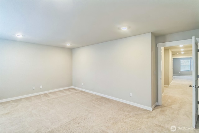 spare room with light colored carpet, baseboards, and recessed lighting