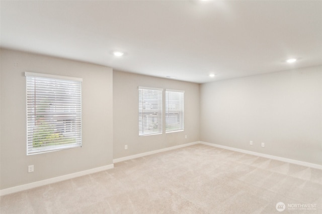 empty room with light colored carpet, baseboards, recessed lighting, and healthy amount of natural light
