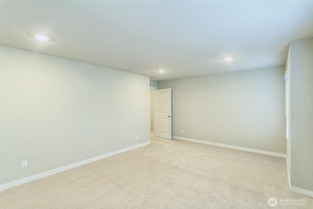 empty room with recessed lighting, light colored carpet, and baseboards
