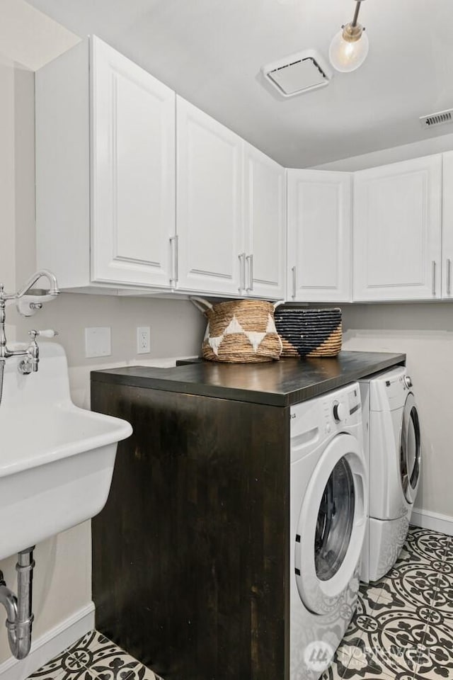 725 1st St S Unit 104, Kirkland, WA 98033 - laundry area featuring separate washer and dryer, cabinet space, and baseboards