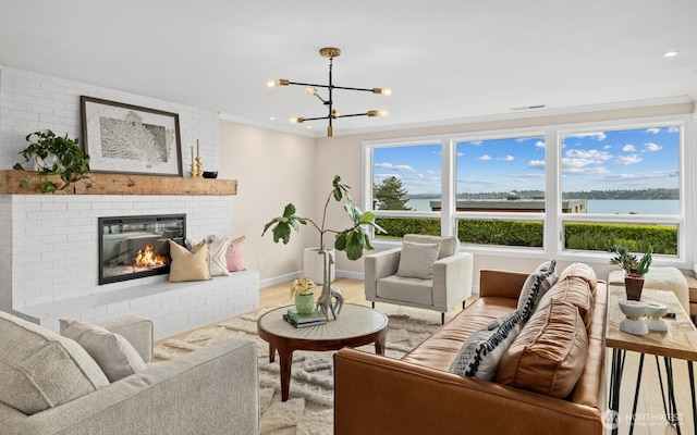 725 1st St S Unit 104, Kirkland, WA 98033 - living area featuring a brick fireplace, a chandelier, crown molding, baseboards, and recessed lighting
