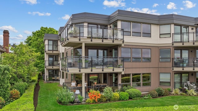 725 1st St S Unit 104, Kirkland, WA 98033 - back of house featuring a balcony and a lawn