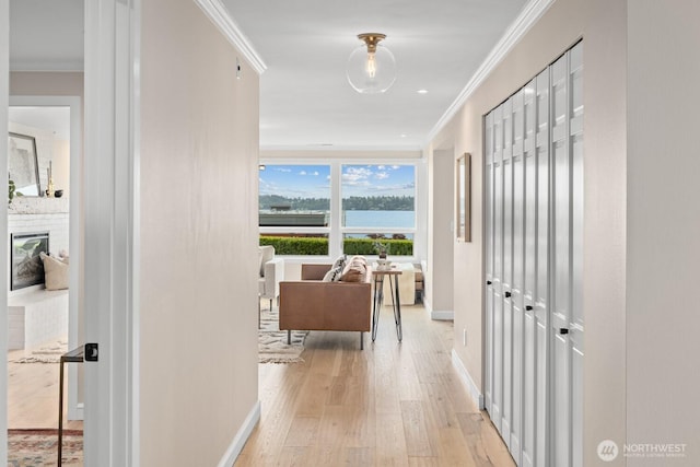 725 1st St S Unit 104, Kirkland, WA 98033 - hallway featuring light wood finished floors, crown molding, and baseboards