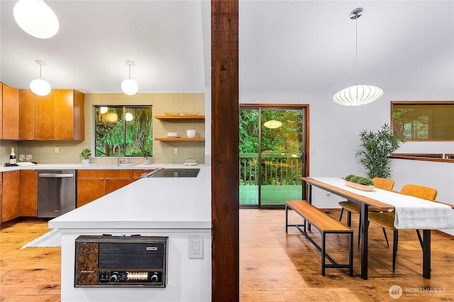 5471 NE Foster Rd, Bainbridge Island, WA 98110 - kitchen featuring stainless steel dishwasher, brown cabinetry, light wood-type flooring, a sink, and light countertops