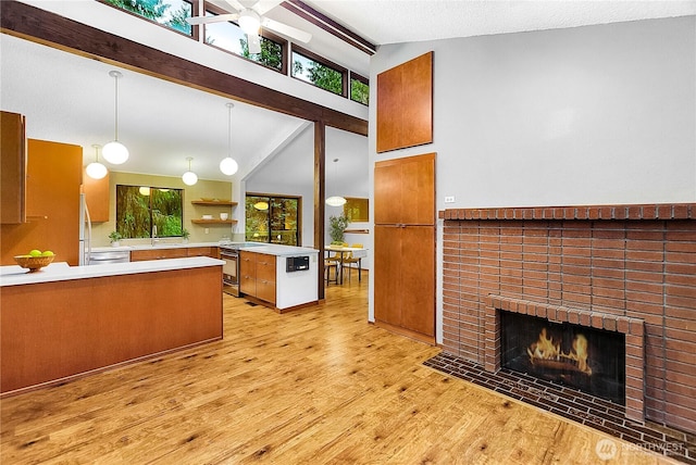 5471 NE Foster Rd, Bainbridge Island, WA 98110 - kitchen featuring brown cabinets, light wood-type flooring, ceiling fan, a sink, and vaulted ceiling
